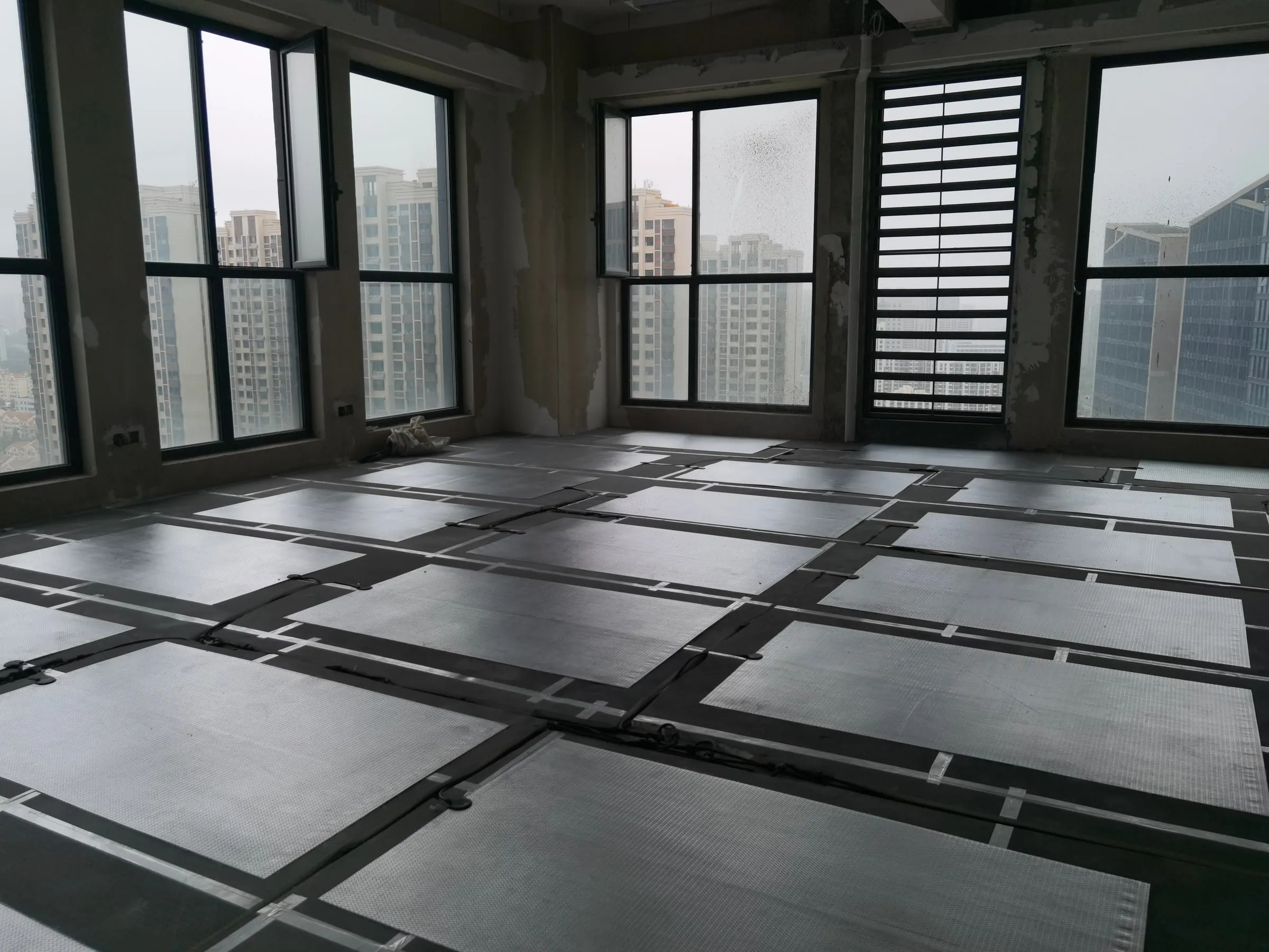Close view of SafeTech EGS heaters and their taped seams on an office floor
