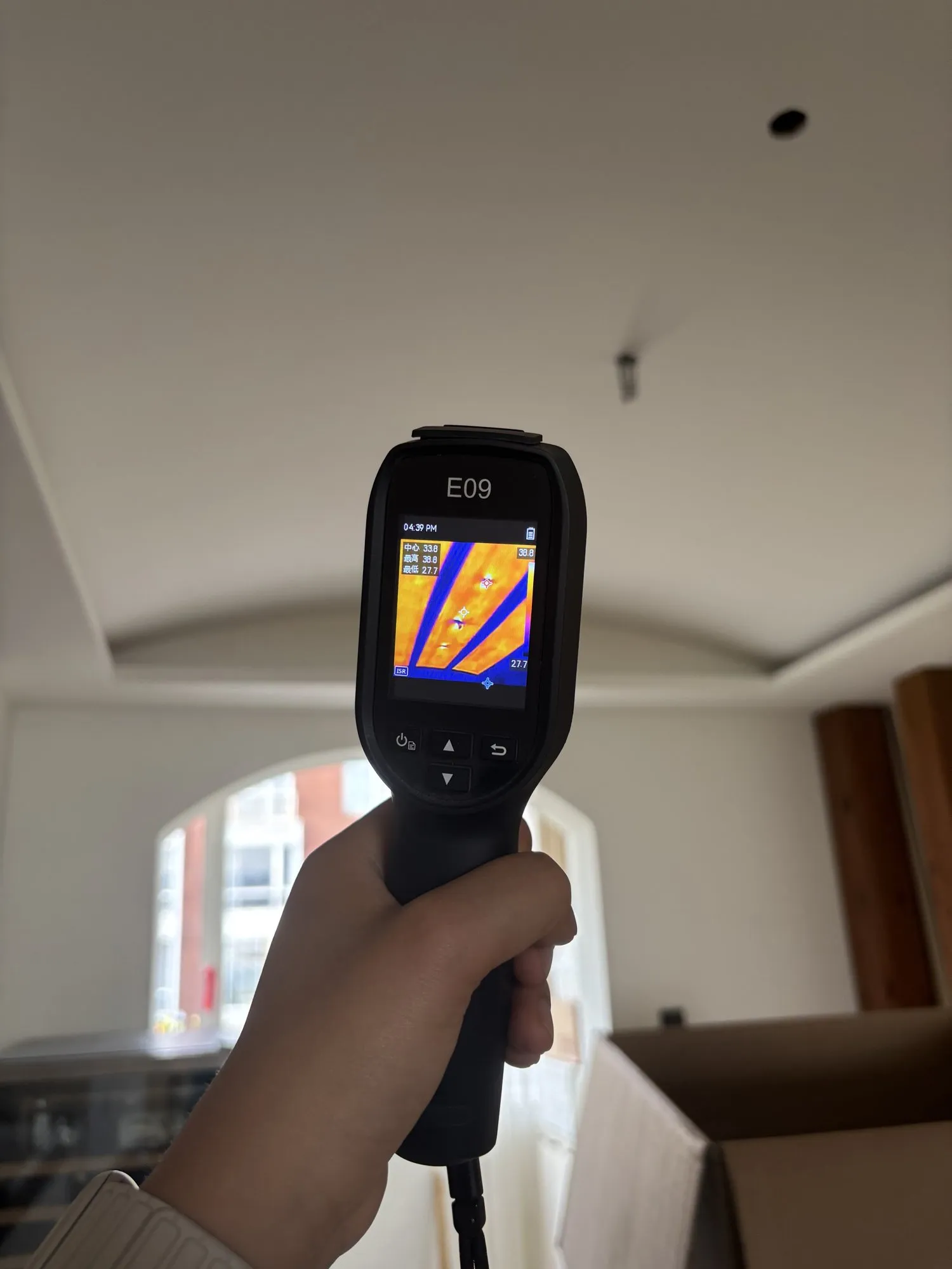 A thermal camera pointed at the curved dining-room ceiling, showing warm stripes where the heating is