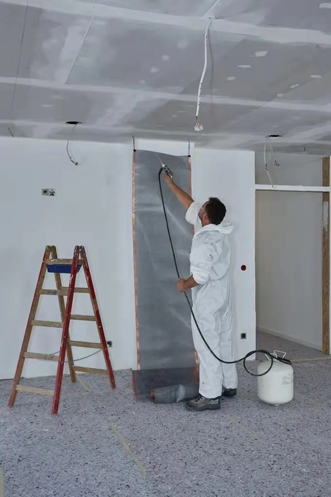 An installer smoothing a length of ComfortScrim onto a wall