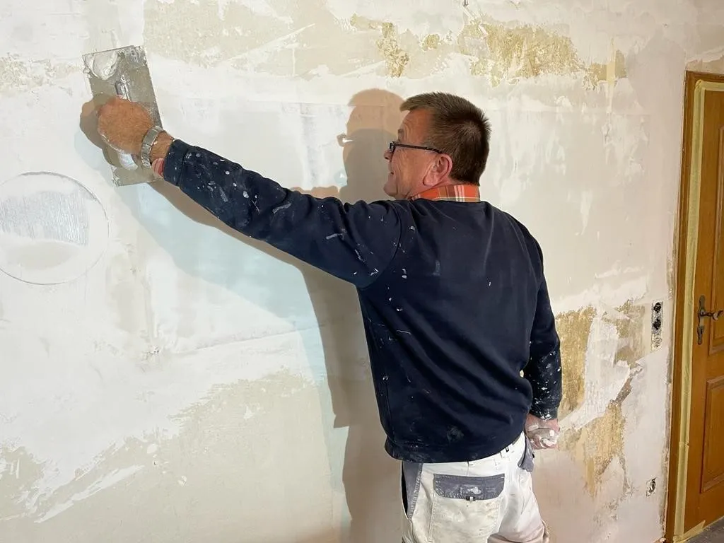 A plasterer skimming over ComfortScrim on an old European wall